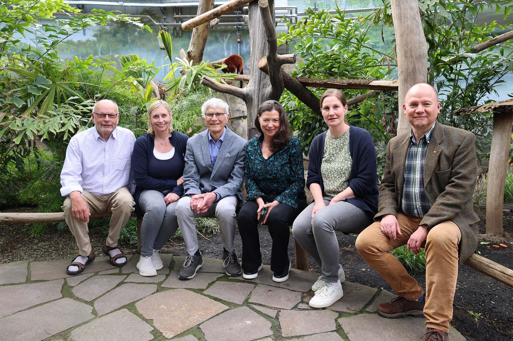 150 Jahre Die Leitung des Allwetterzoos, des Zoovereins und des Pferdemuseums sitzt auf einem Geländer vorm Gehege der Roten Varis