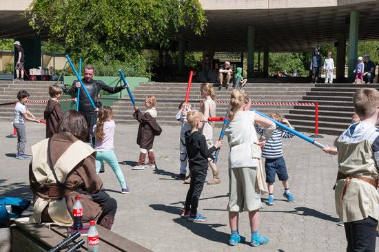 Kinder lernen in der Lichtschwertschule wie sie eine Show mit Lichtschwertern machen können